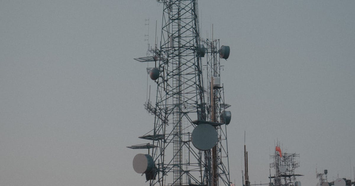 Communication antenna towers on a hillside at dusk