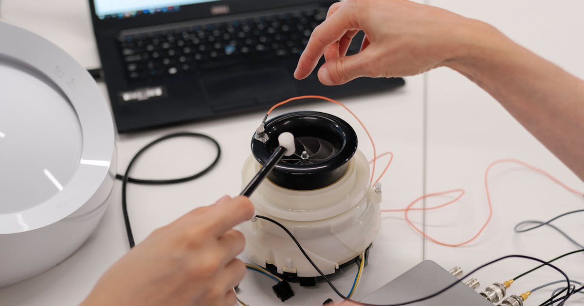 Engineers testing electronic equipment with a laptop in a lab