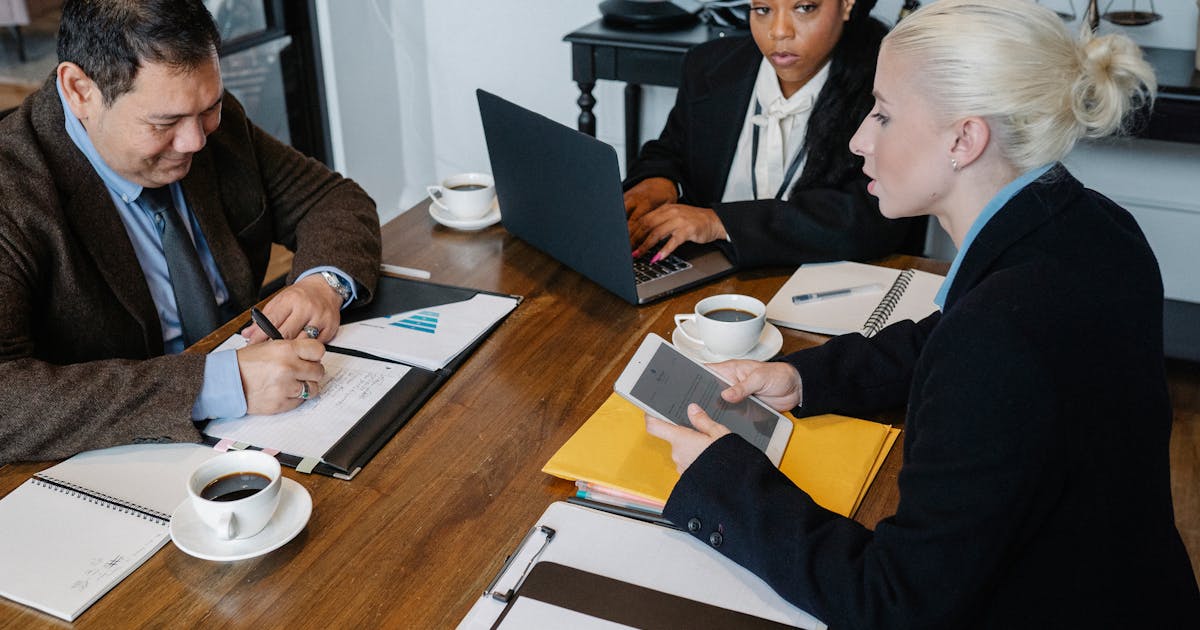 Business team discussing documents and laptop at a meeting table
