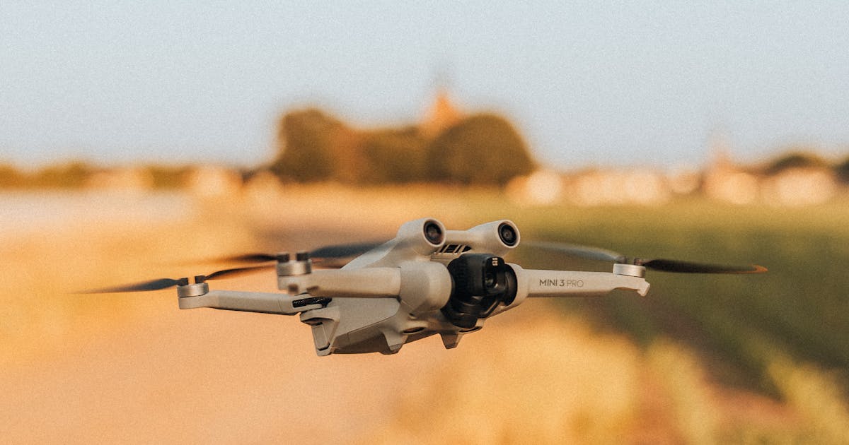 Small drone flying low over a rural field