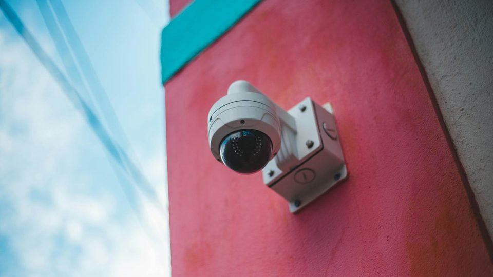 A close-up of a security camera mounted on a wall.