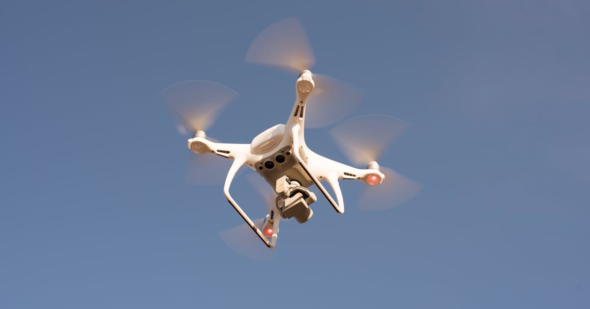 Small drone flying against the sky